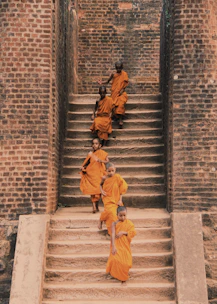 A group of young members warmly welcoming a new member in saffron attire.