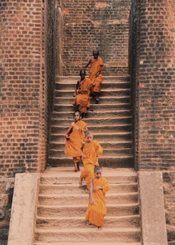 man in yellow jacket walking on gray concrete stairs