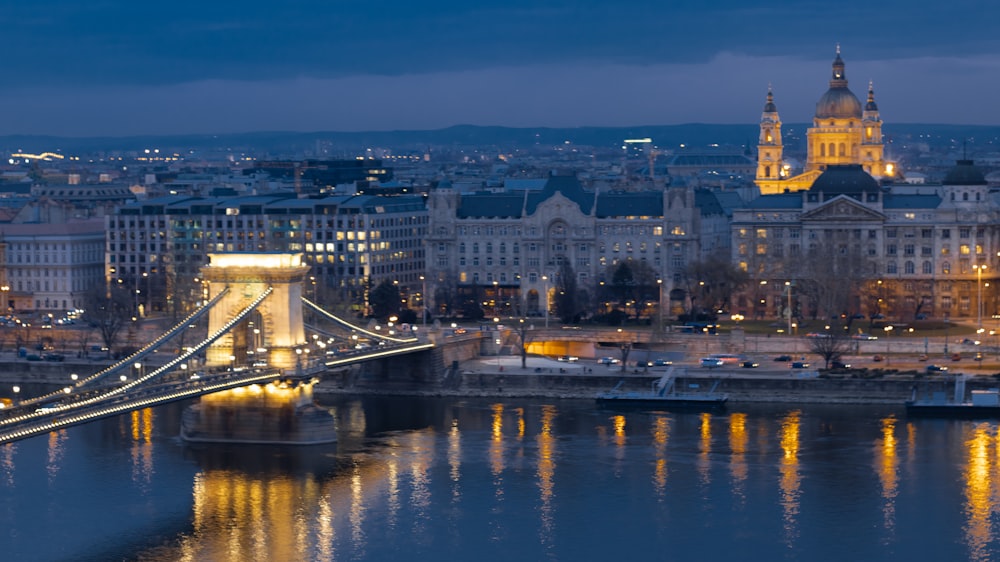 bridge over river near city buildings during night time