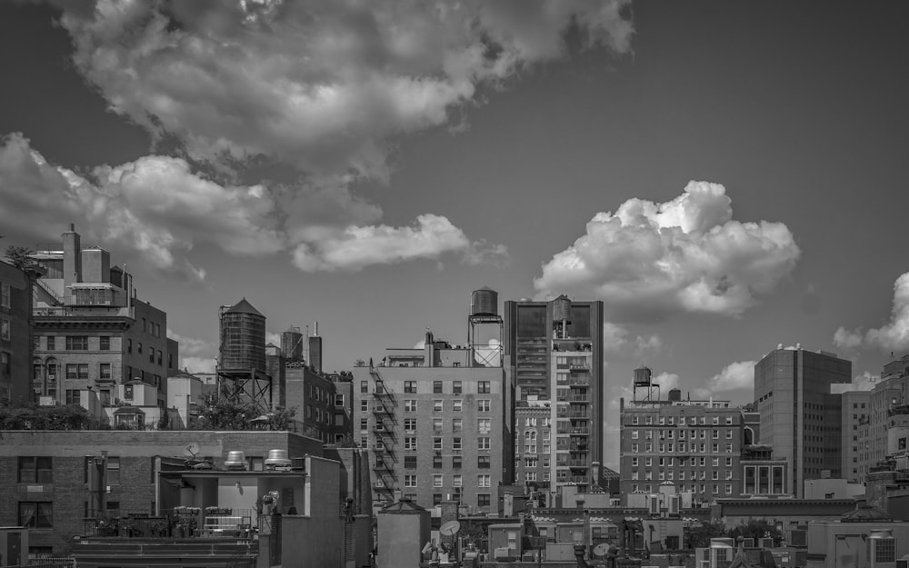 grayscale photo of city buildings under cloudy sky