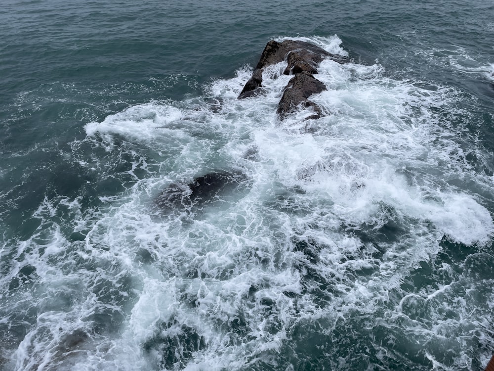 brown rock formation on body of water during daytime