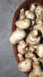 Bright white champiñones mushrooms arranged neatly in a rustic basket.