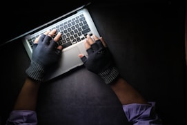 person in black long sleeve shirt using macbook pro