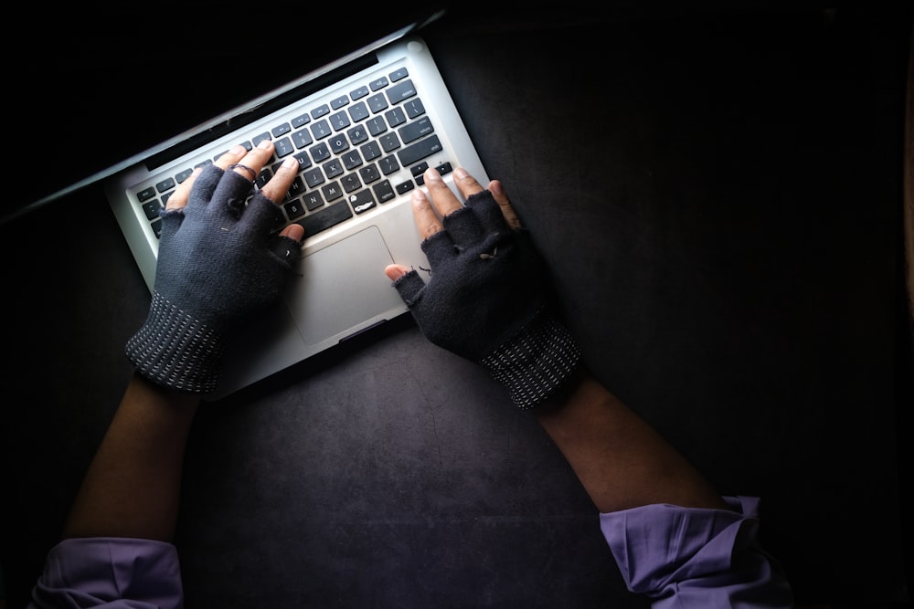 Persona in camicia nera a maniche lunghe con MacBook Pro