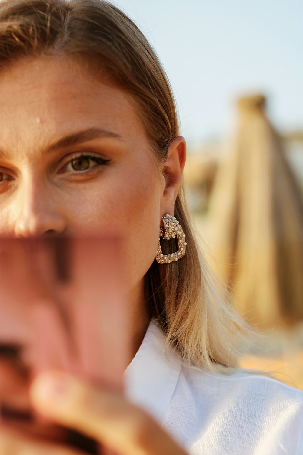 woman in white shirt wearing gold earrings