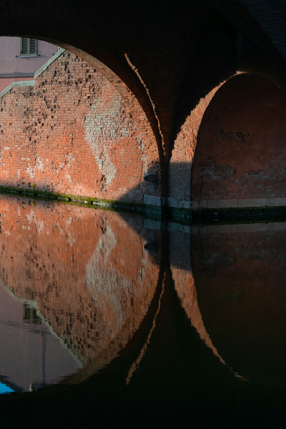 日中の水面に映る茶色のコンクリート橋