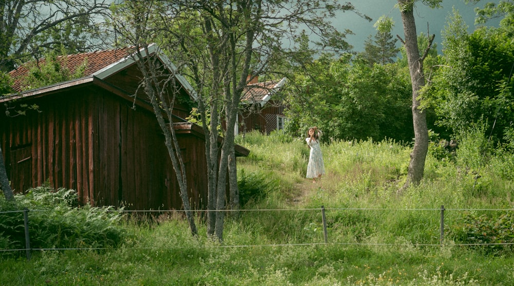 woman in white dress standing on green grass field during daytime