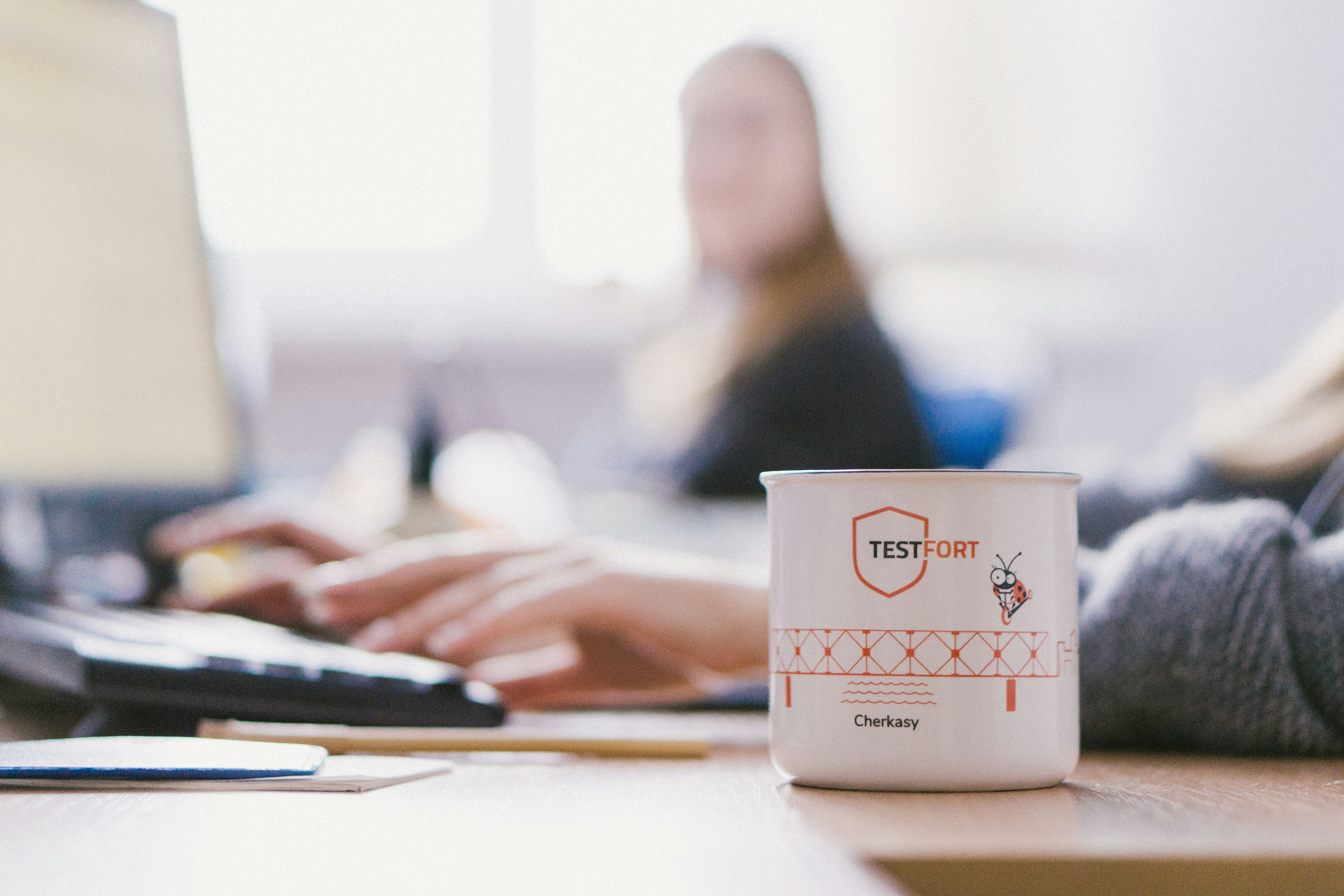 white and pink ceramic mug on white table
