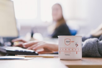 white and pink ceramic mug on white table