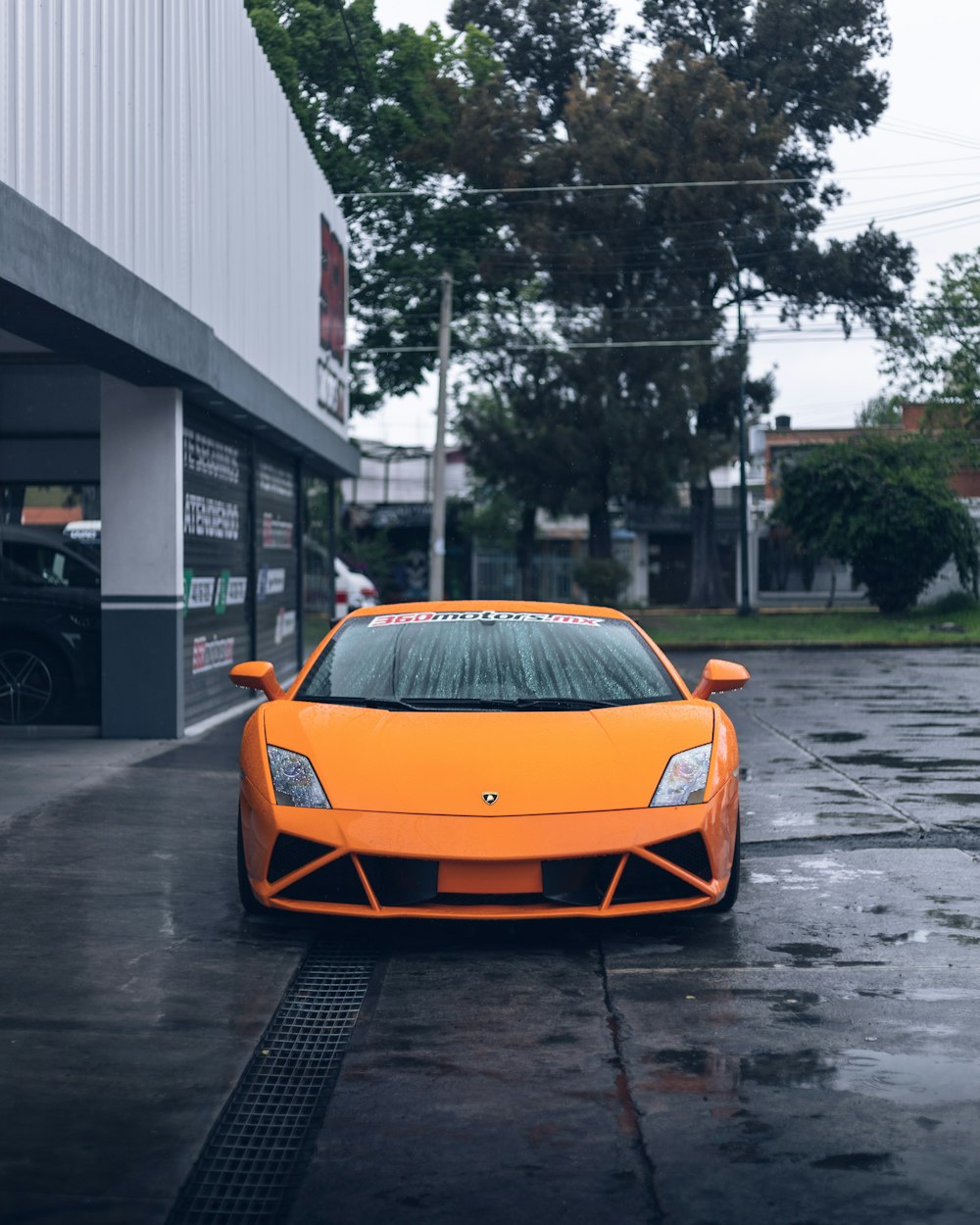 orange lamborghini aventador parked on the side of the road