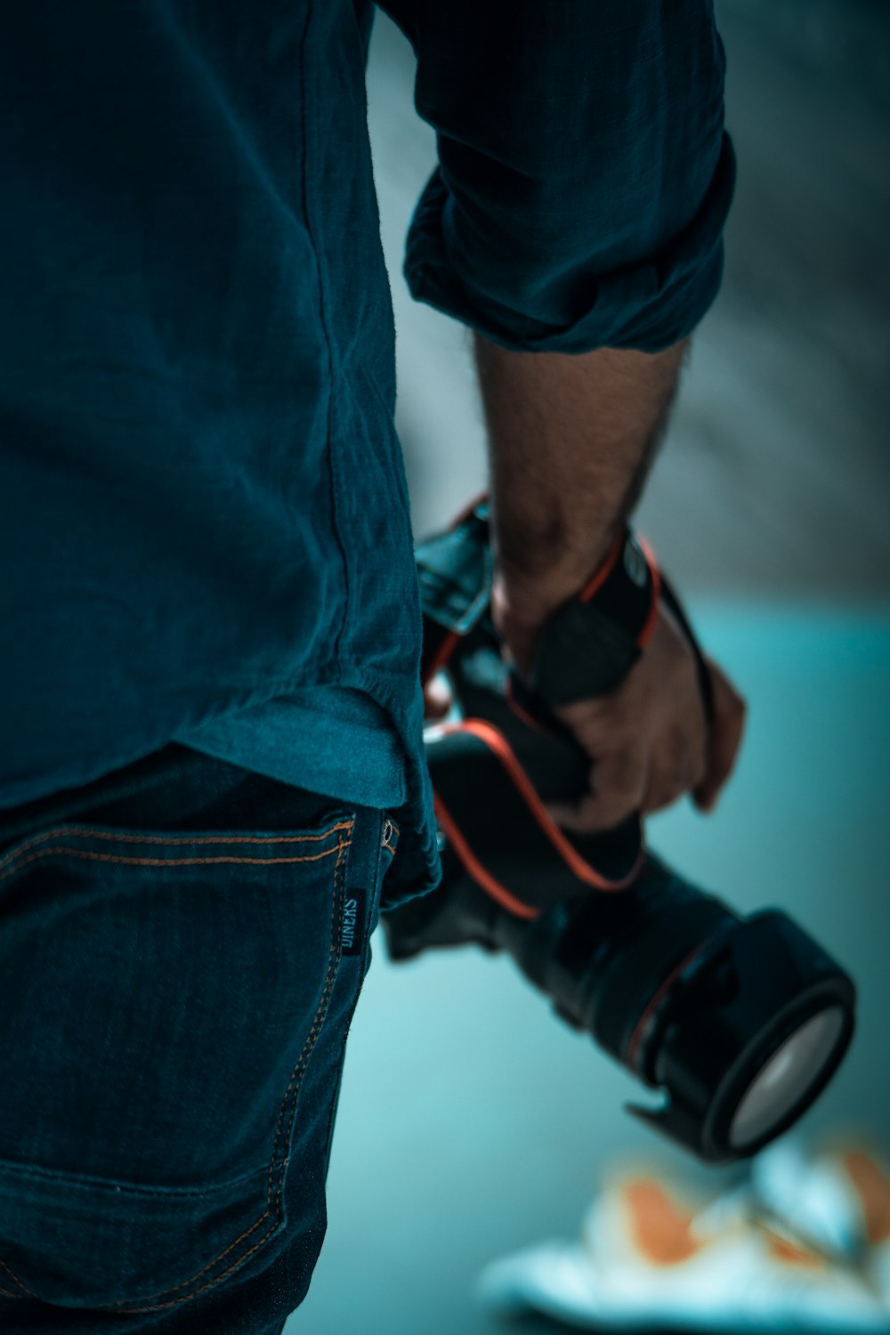 person in blue denim jeans with black and red strap on his left hand