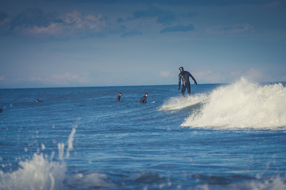 people surfing on sea waves during daytime