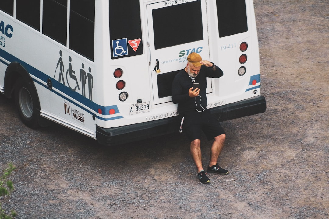 woman in black tank top and black shorts standing beside white bus during daytime