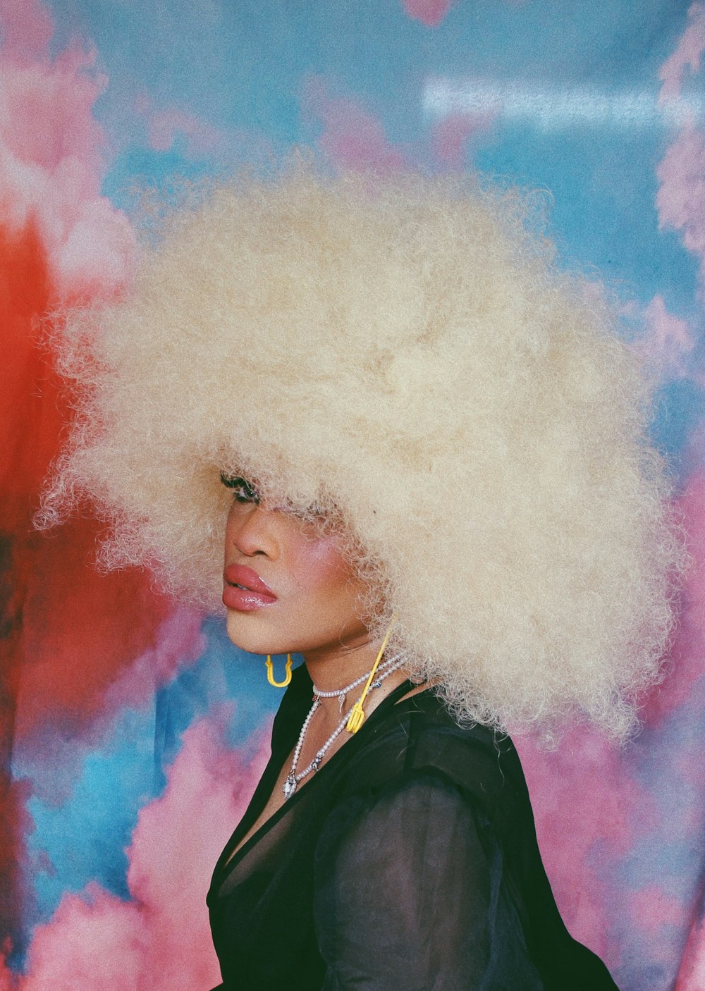 woman in black coat with white and pink powder on her face