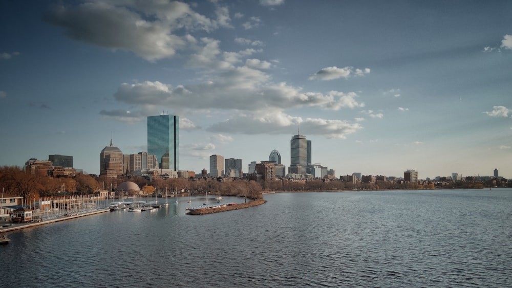 city skyline across body of water under blue and white sunny cloudy sky during daytime