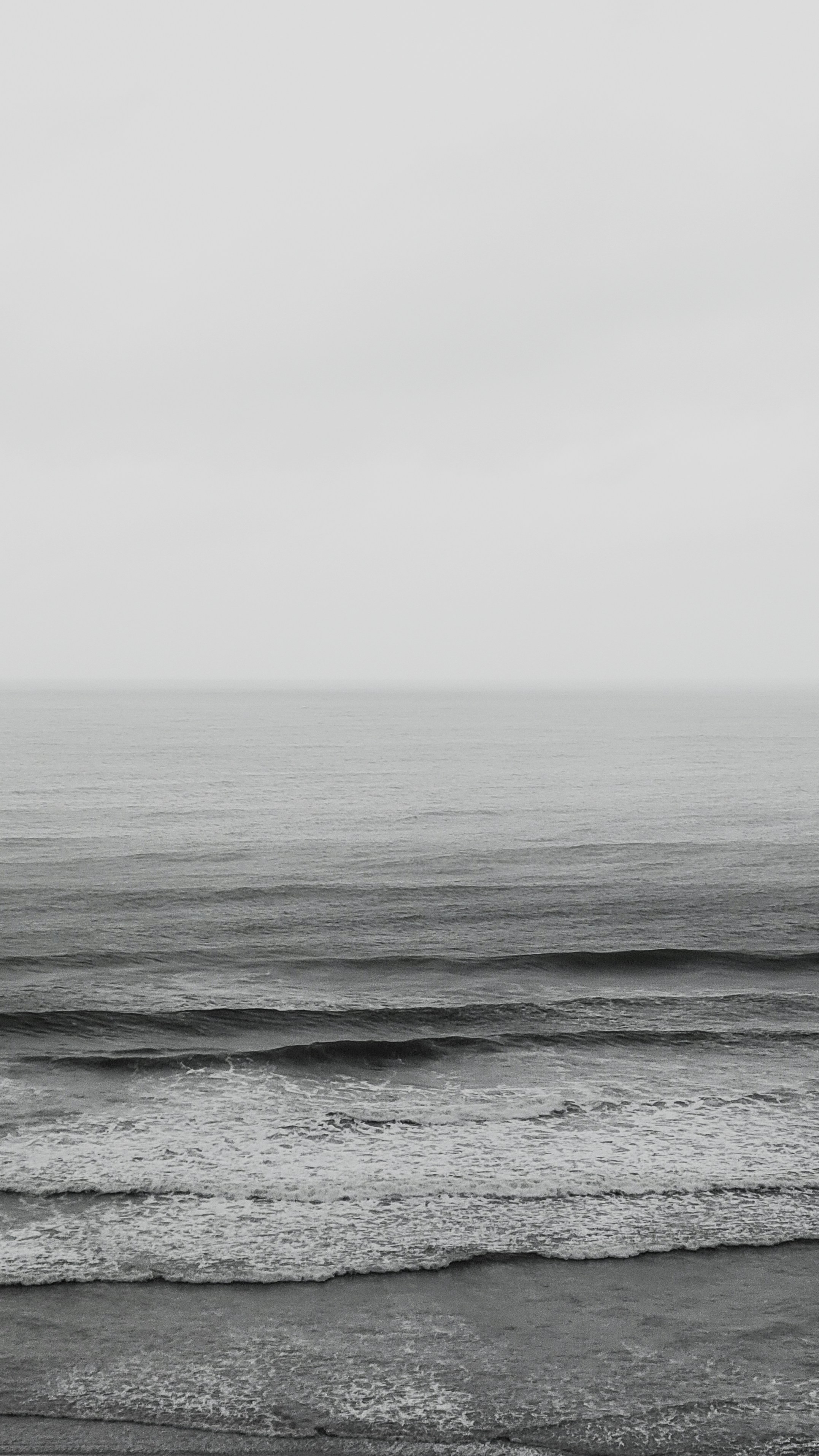 ocean waves under white sky during daytime