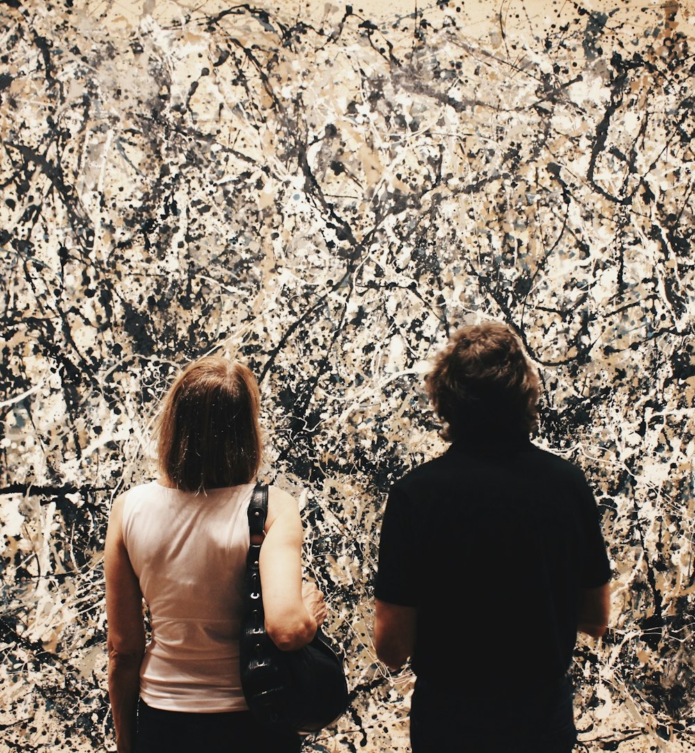 2 women standing near brown trees during daytime