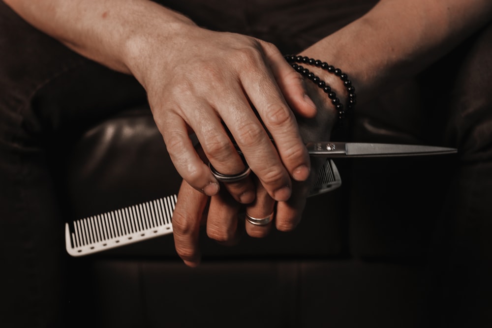 une personne tenant un couteau et un peigne