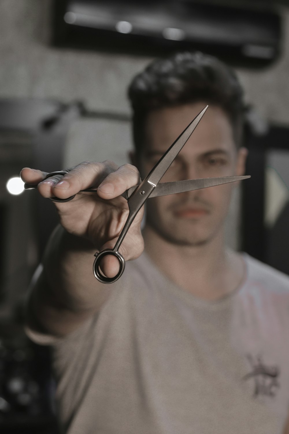 person holding black handled scissors