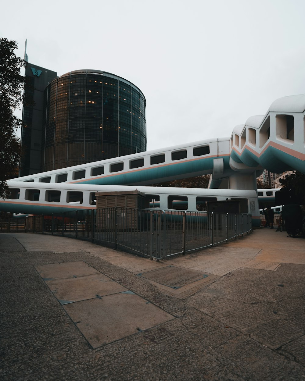 a white and blue train sitting next to a tall building