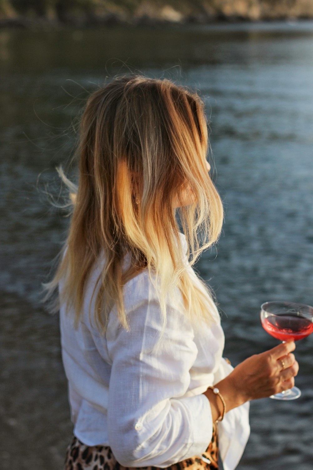woman in white dress shirt holding wine glass