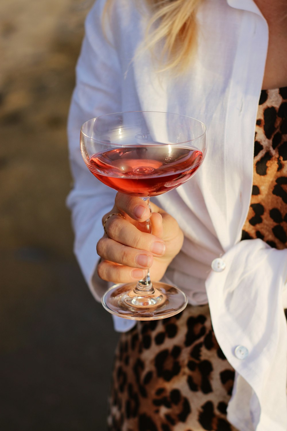 Persona sosteniendo una copa de vino transparente