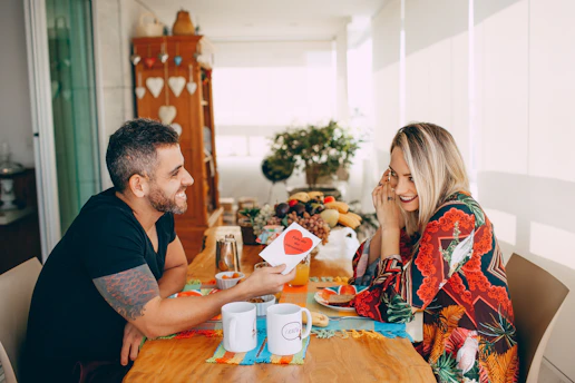man and woman sitting on chair in front of table