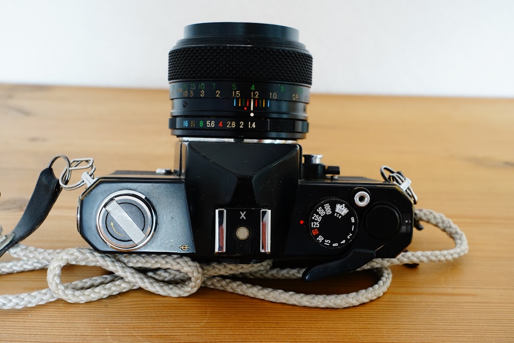 black and silver dslr camera on brown wooden table