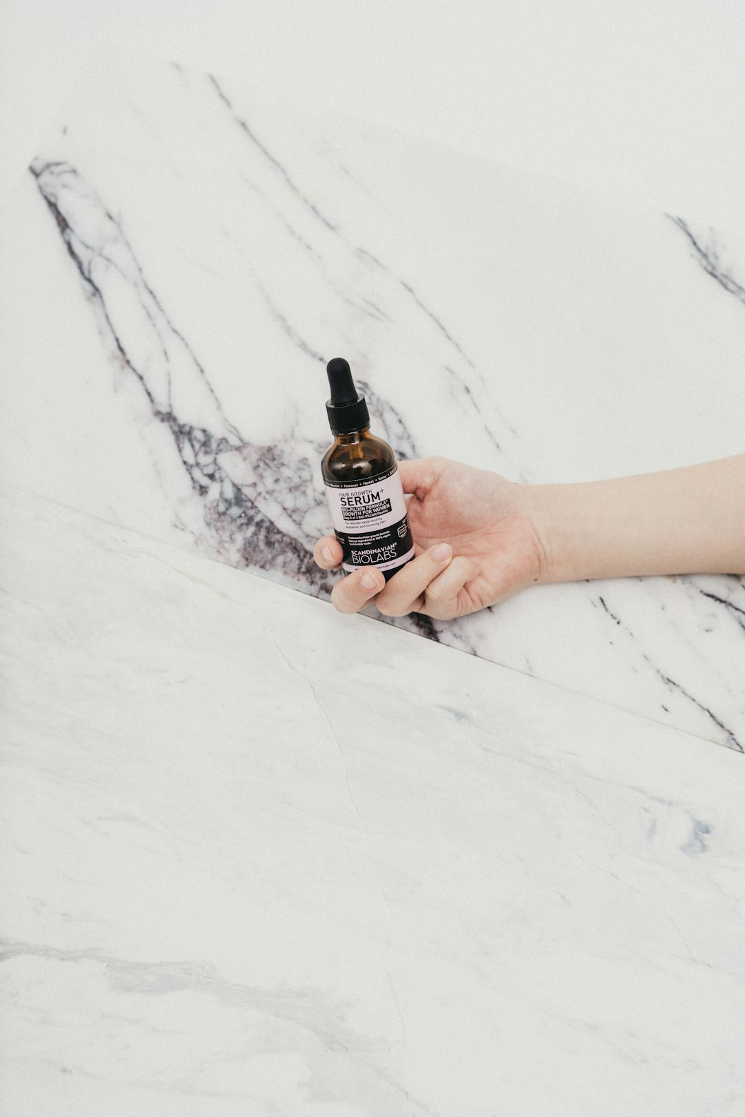 person holding black and white labeled bottle