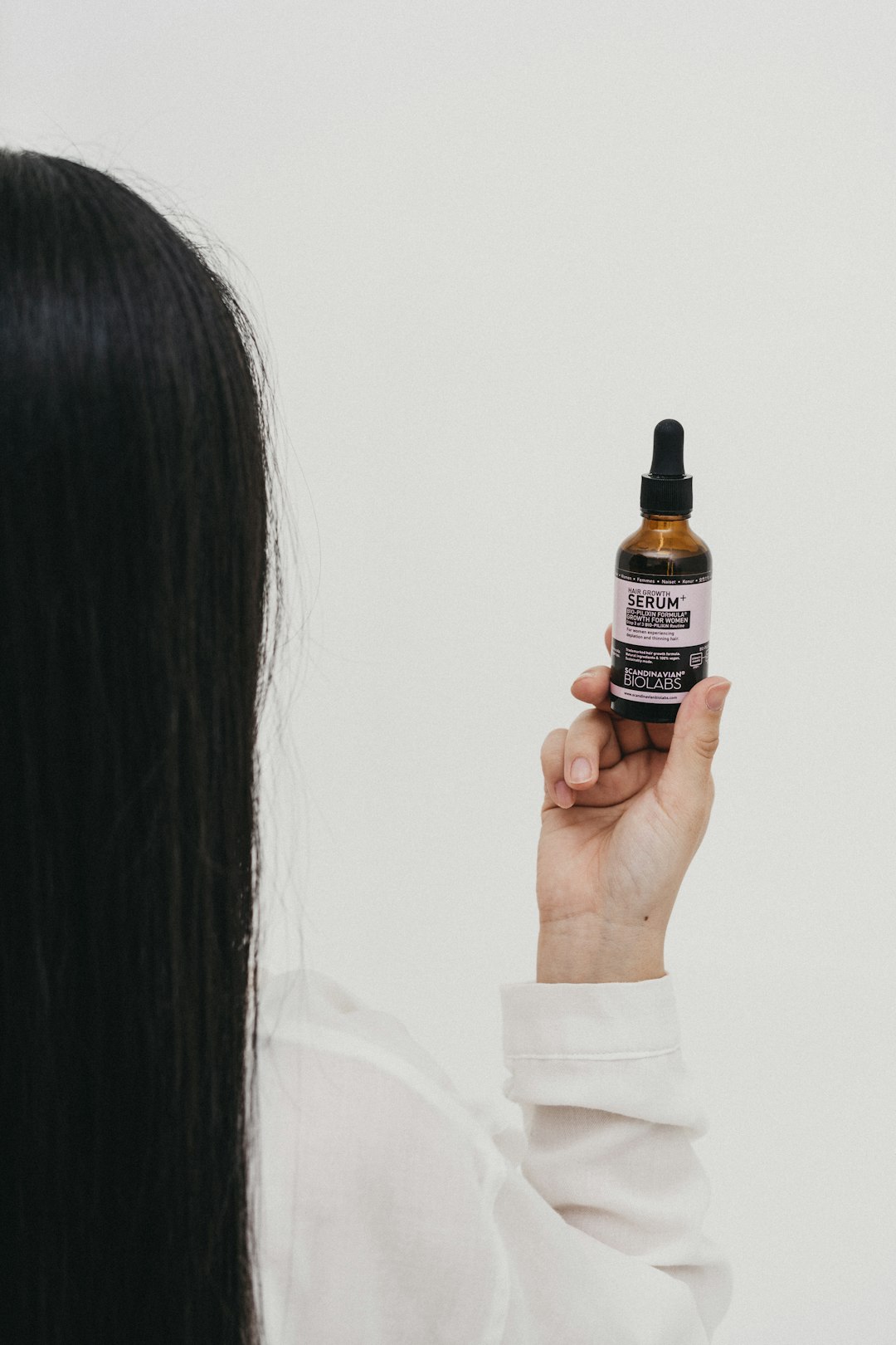 person holding black and white labeled bottle