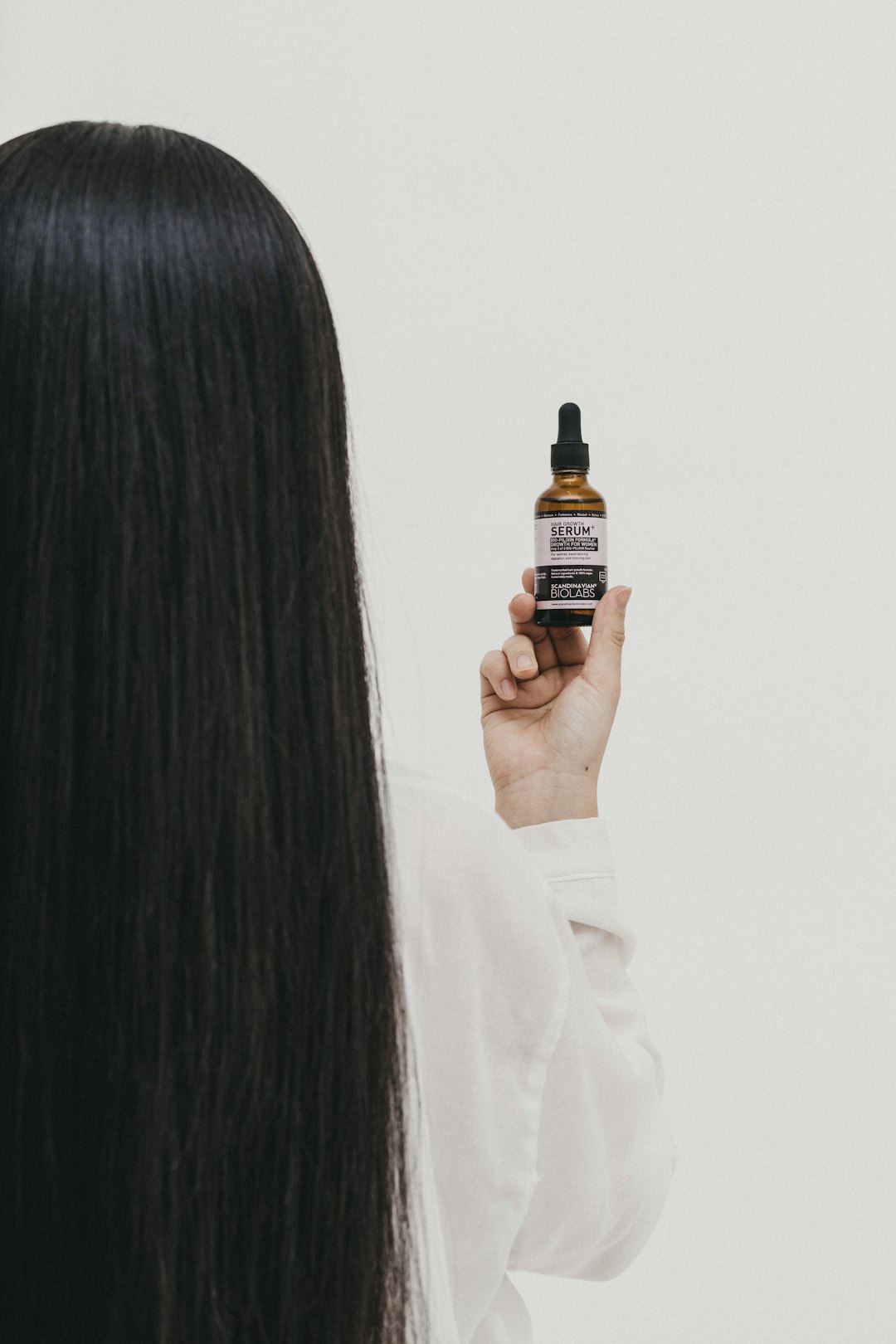 woman holding black and yellow labeled bottle