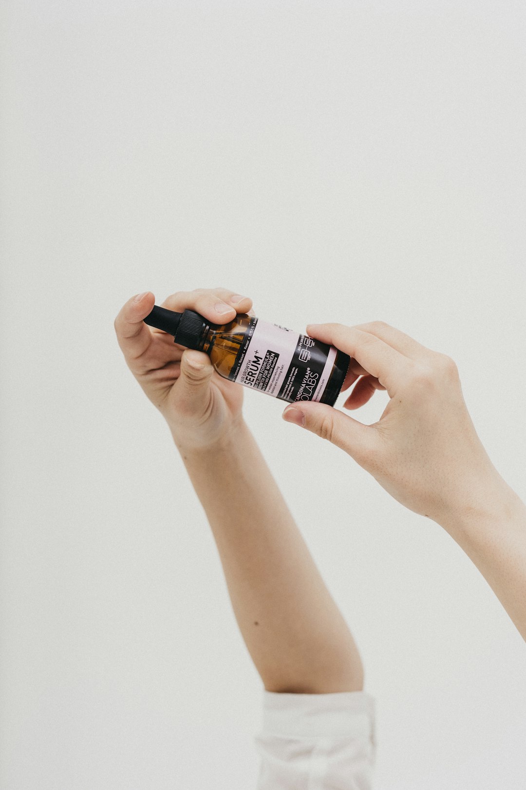 person holding black and white labeled bottle