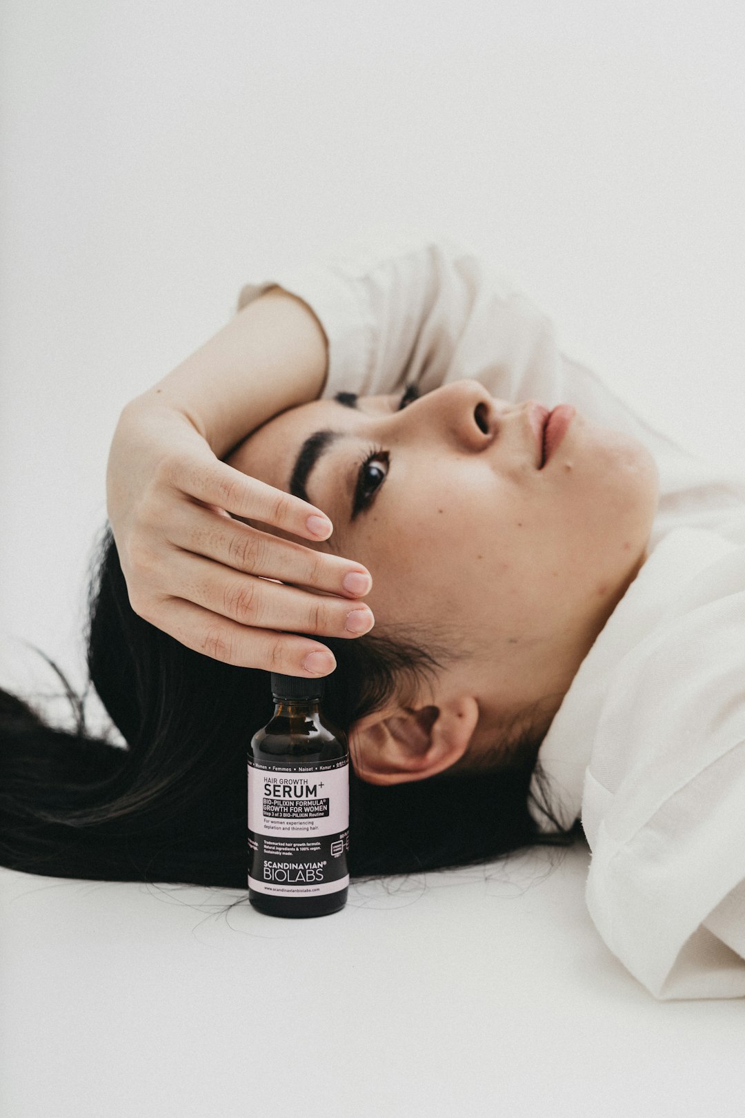 woman in white shirt holding bottle