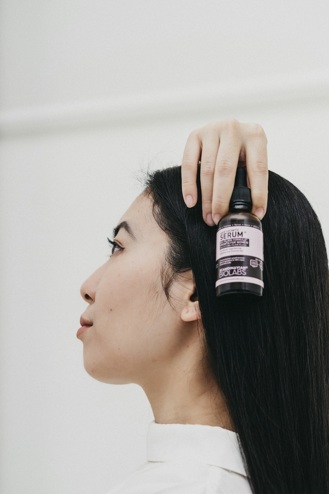 woman holding black and white labeled bottle