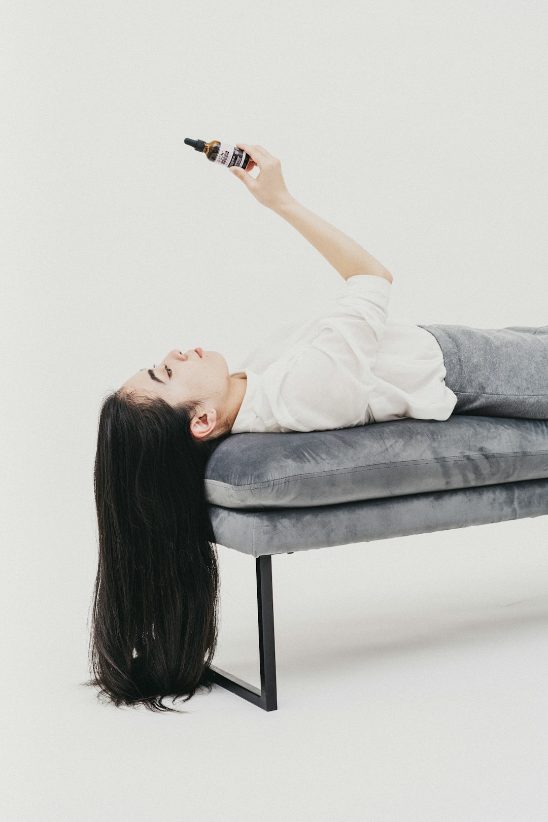 woman in white t-shirt lying on gray couch