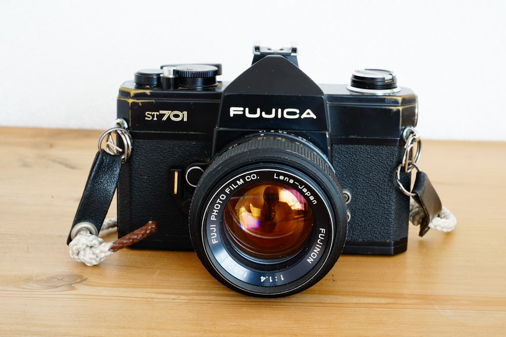 black nikon dslr camera on brown wooden table