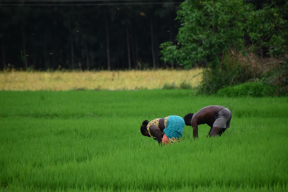 woman in black pants and blue shirt running on green grass field during daytime