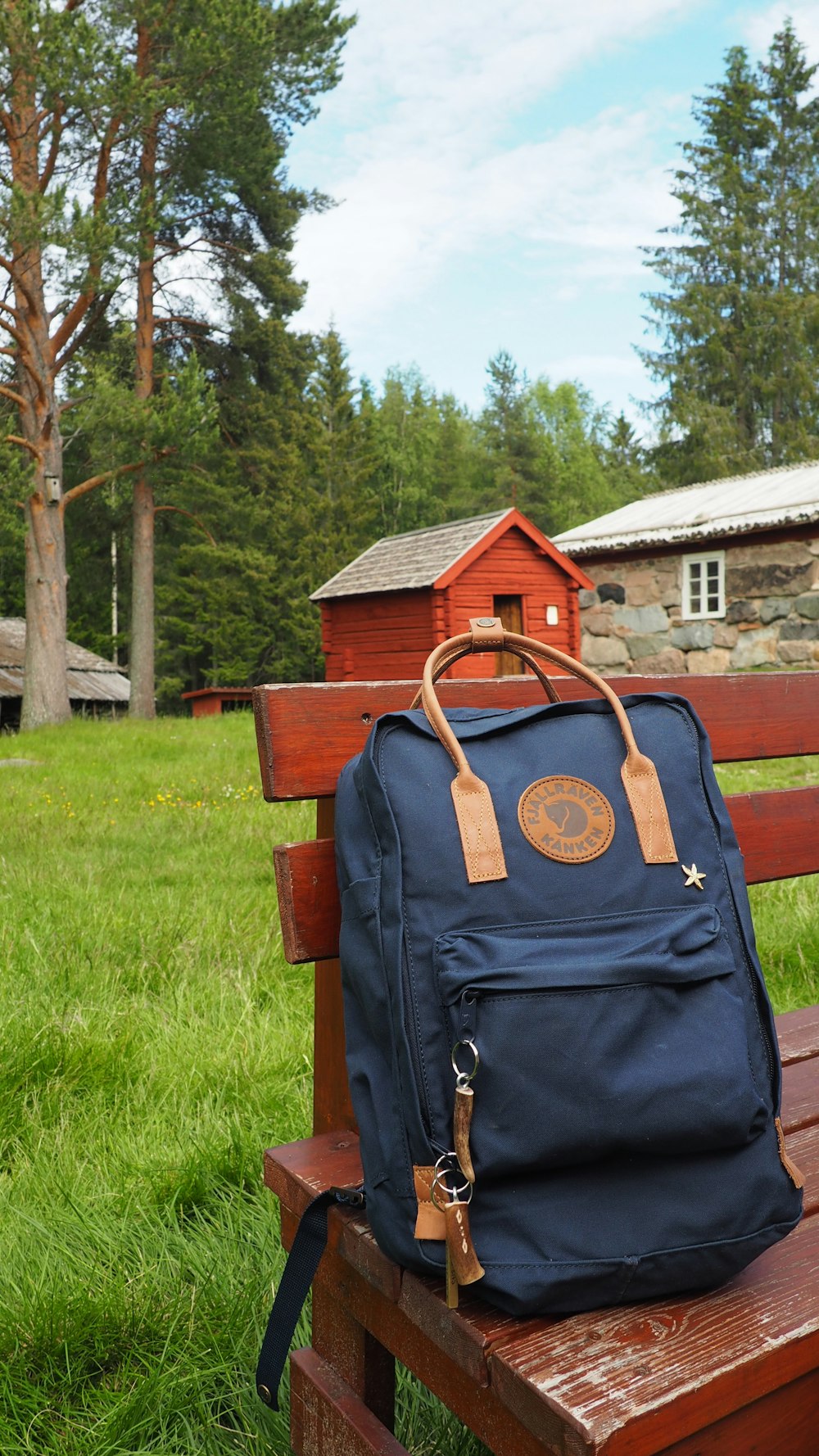 black and brown leather shoulder bag on brown wooden bench