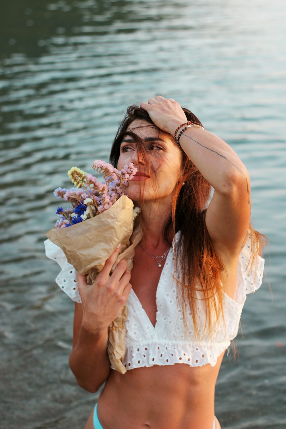 woman in white dress holding bouquet of flowers