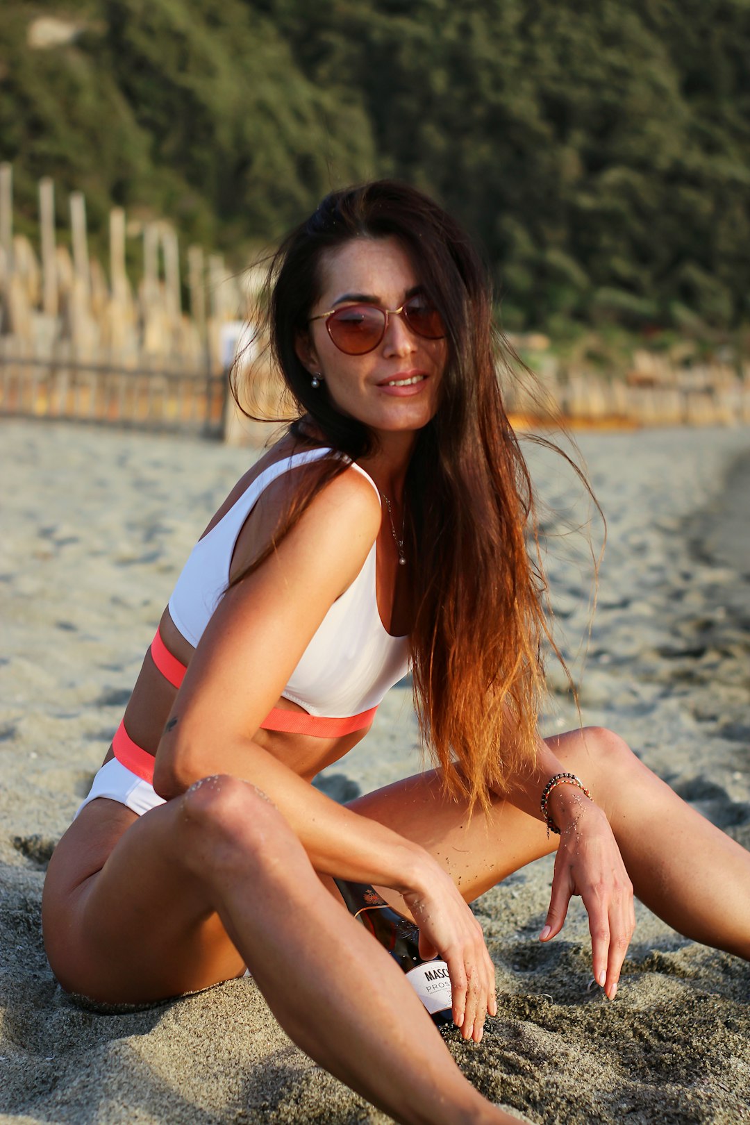 woman in white and red tank top sitting on brown wooden bench during daytime