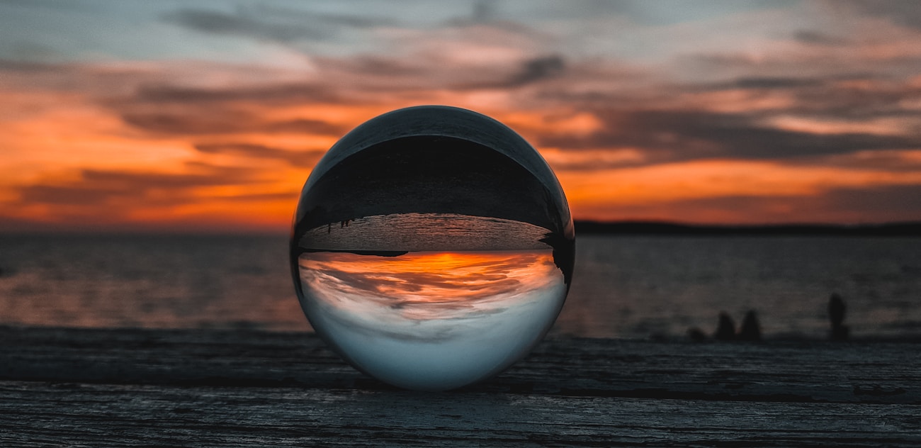 Crystal ball on wooden surface refracting and inverting the background scene