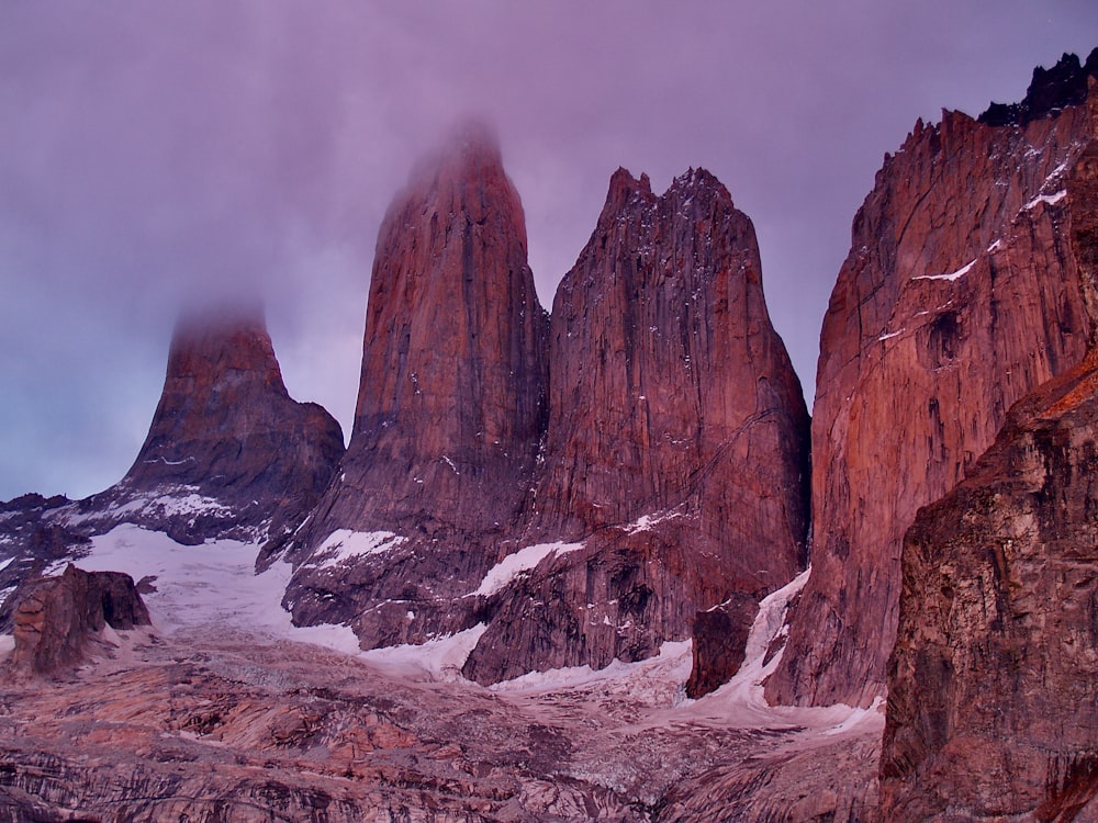 brown rock formation under white clouds during daytime