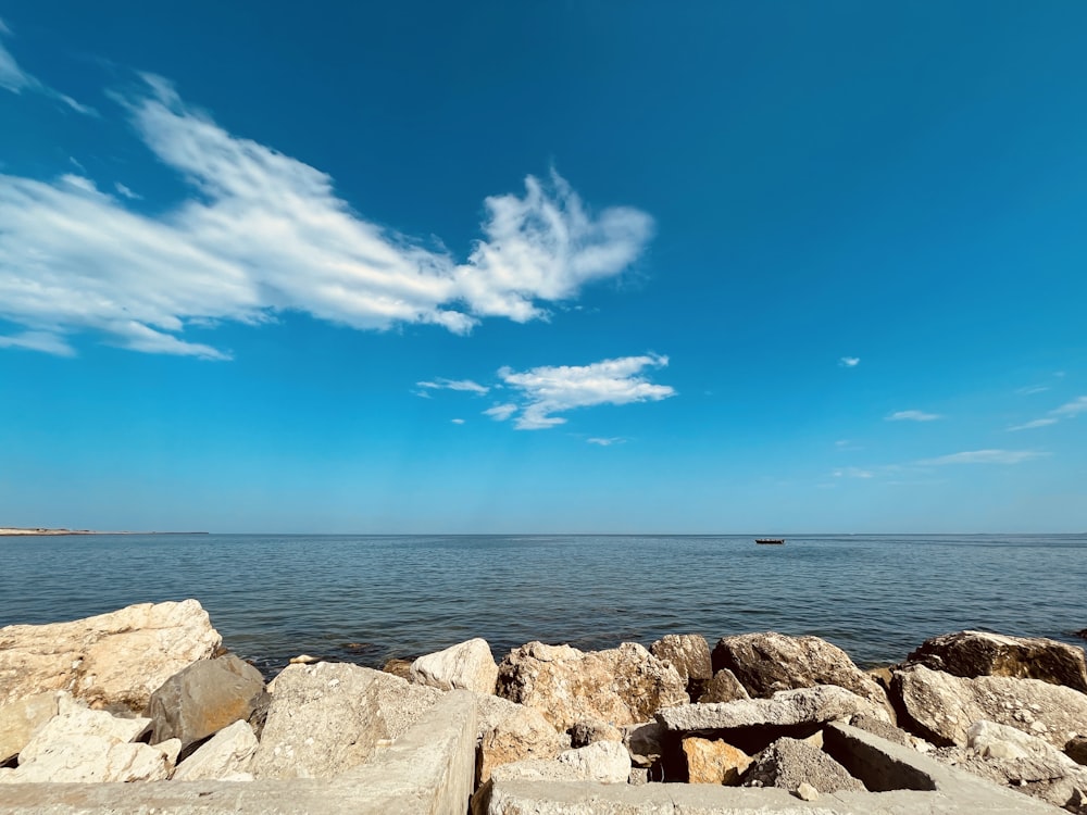 Braune Felsen in der Nähe von Gewässern unter blauem Himmel während des Tages