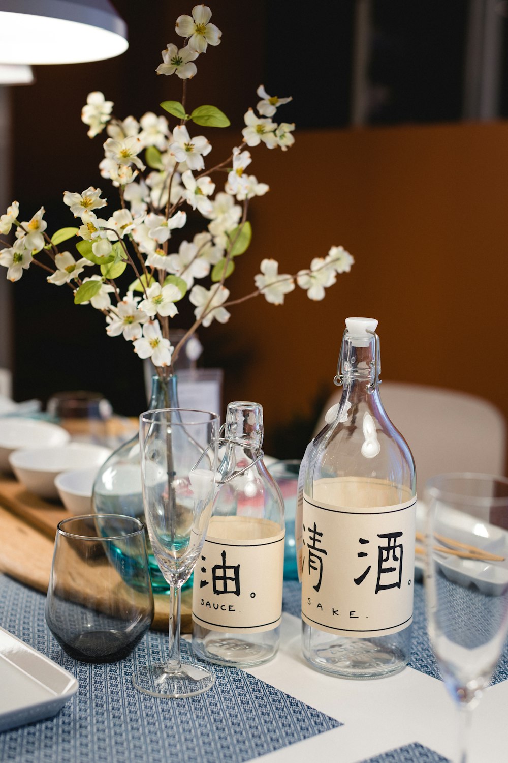 fiori bianchi in bottiglia di vetro trasparente su tavolo di legno marrone