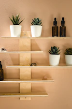 black glass bottles on white wooden shelf