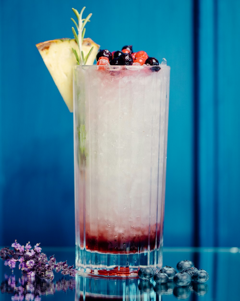 clear drinking glass with ice and black berries