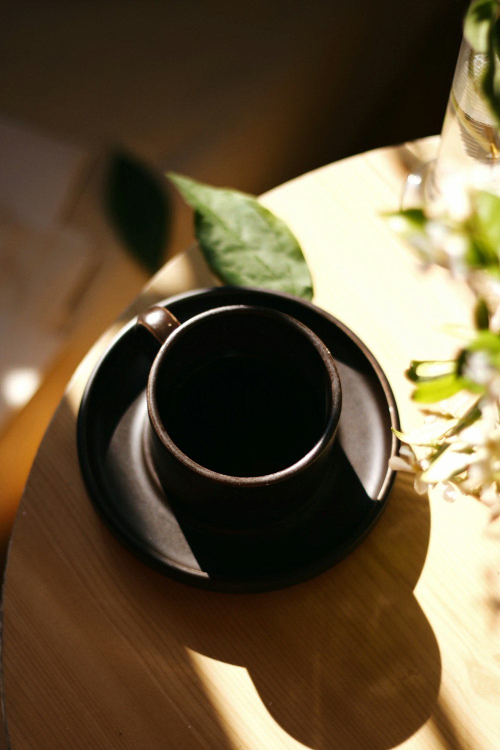 black liquid in black ceramic mug on brown wooden table