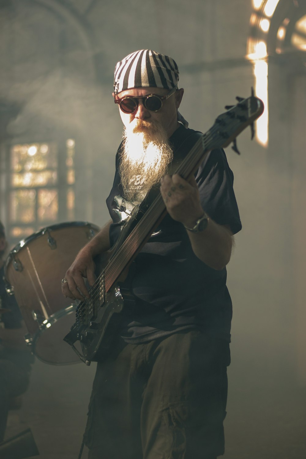 hombre con camiseta negra tocando la guitarra