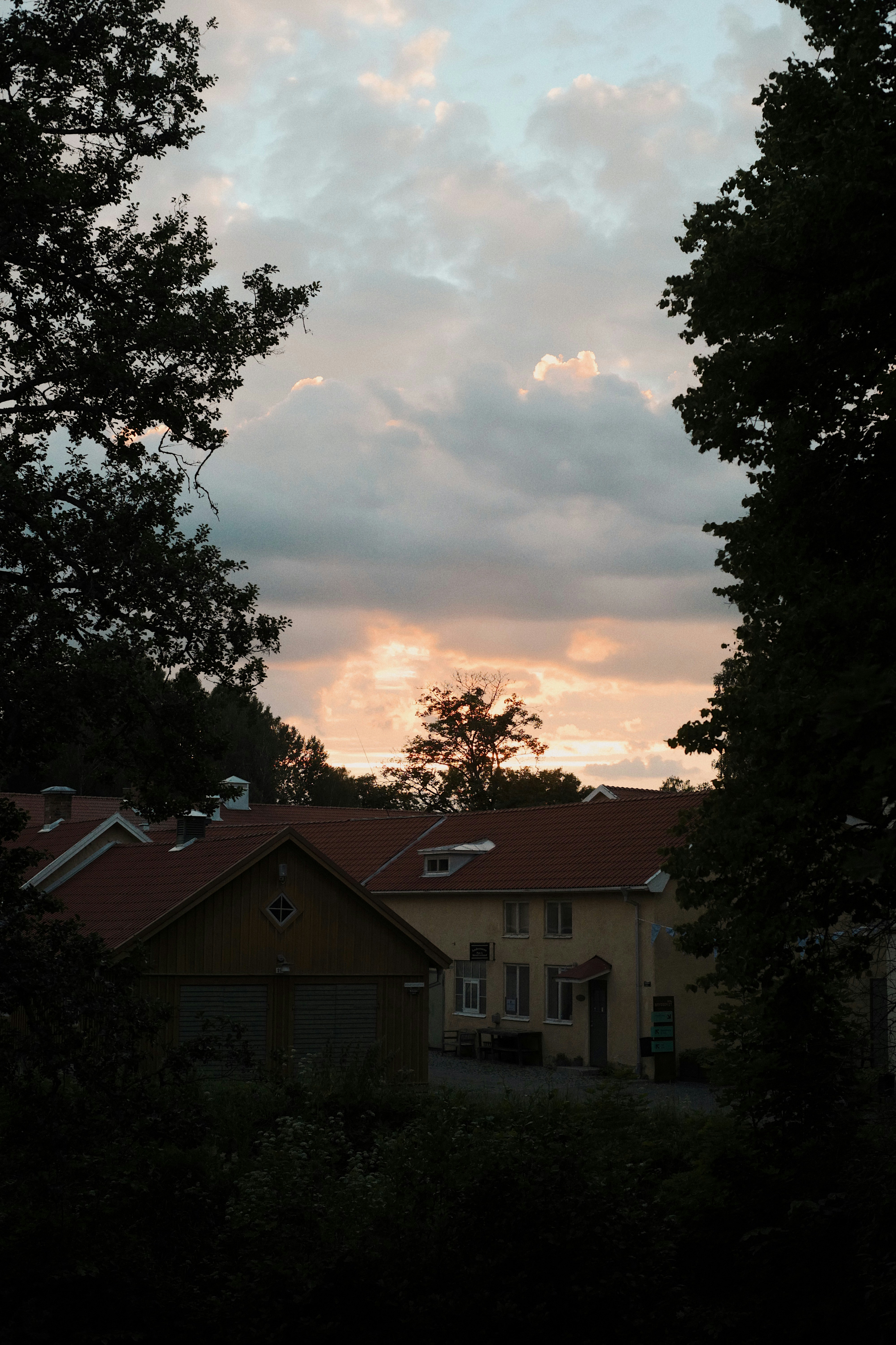 White and brown house near green trees under cloudy sky during daytime ...