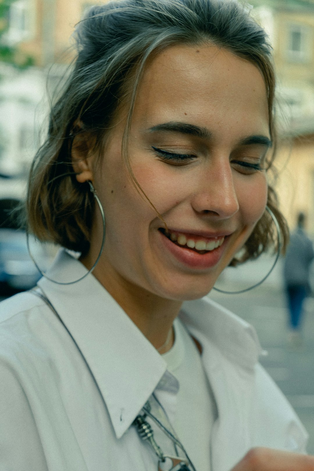 woman in white collared shirt smiling